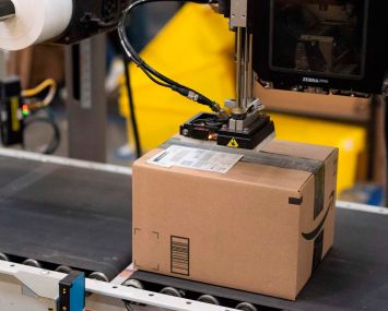 A package is labeled at a SLAM, or scan, label, apply and manifest during a tour of Amazon's Fulfillment Center.