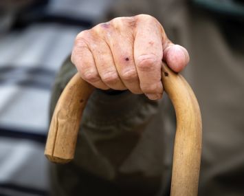 A close-up of a hand on a cane.